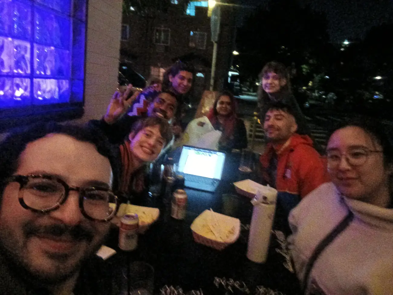 Members of the Homestuck Book Club gather around a table for a group selfie.